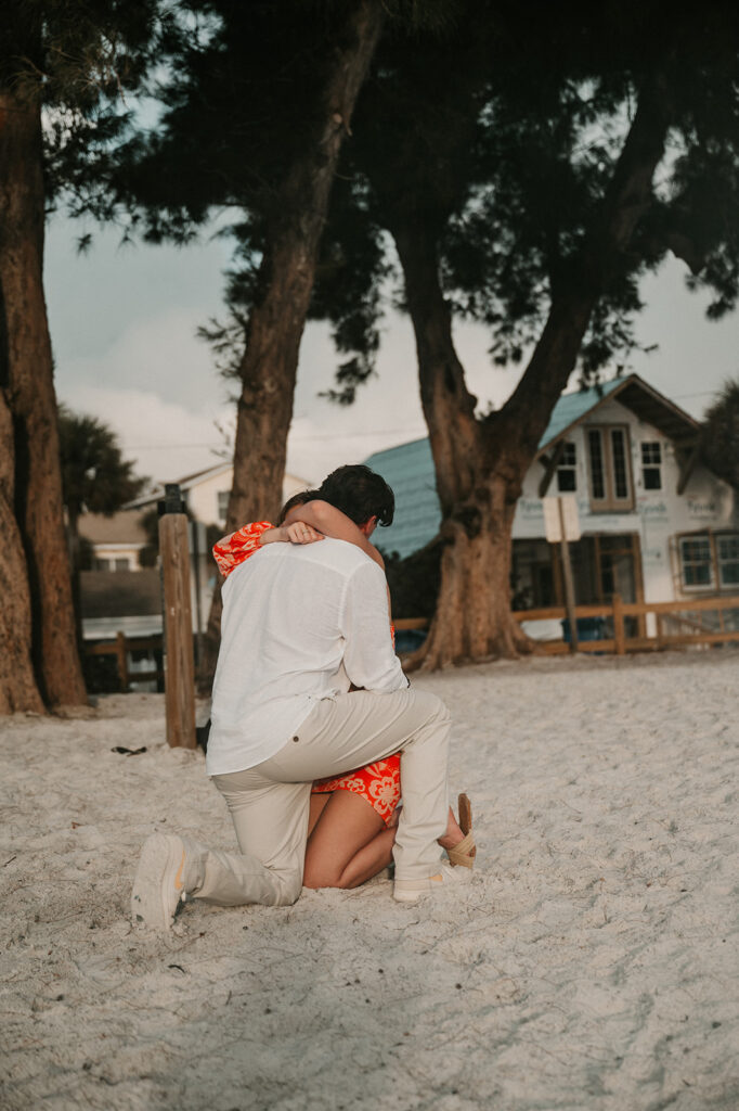 couple hugging after their beach proposal