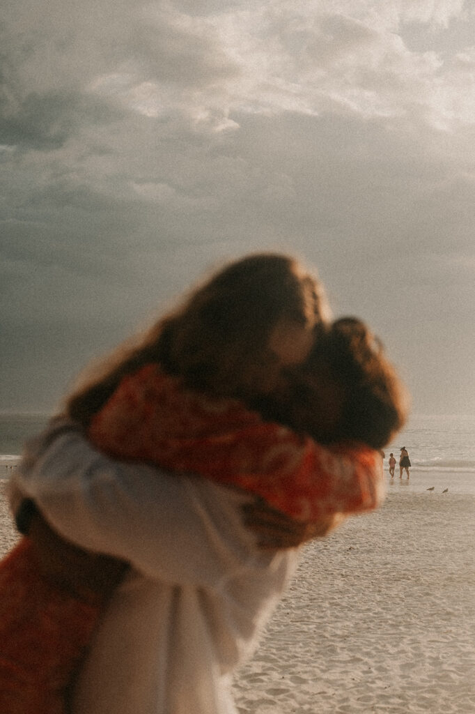 couple hugging at their beach proposal