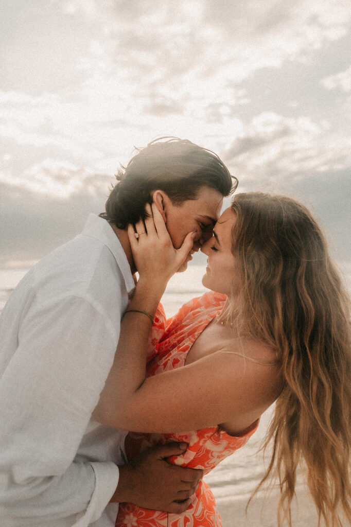 couple kissing each other after their beach proposal