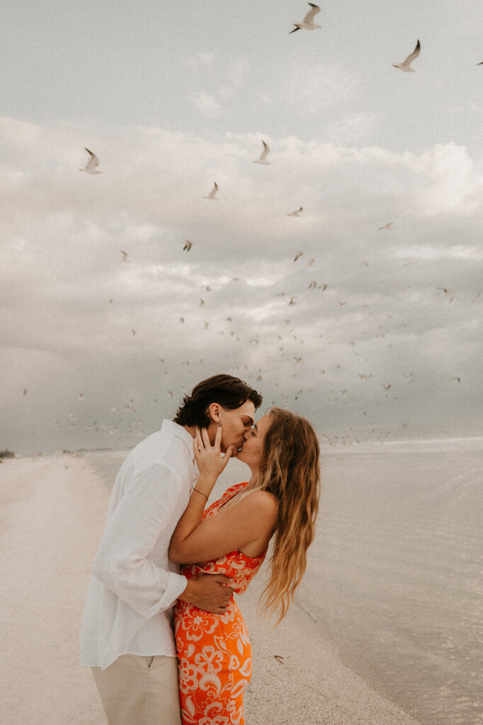 couple kissing after their beach proposal