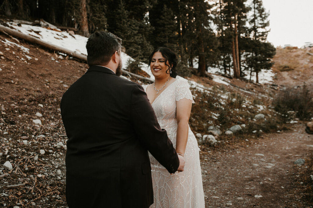 bride and groom holding hands during their first look at their adventurous elopement 