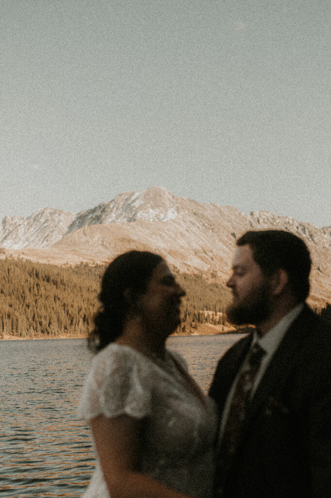 couple looking at each other with the lake in the background