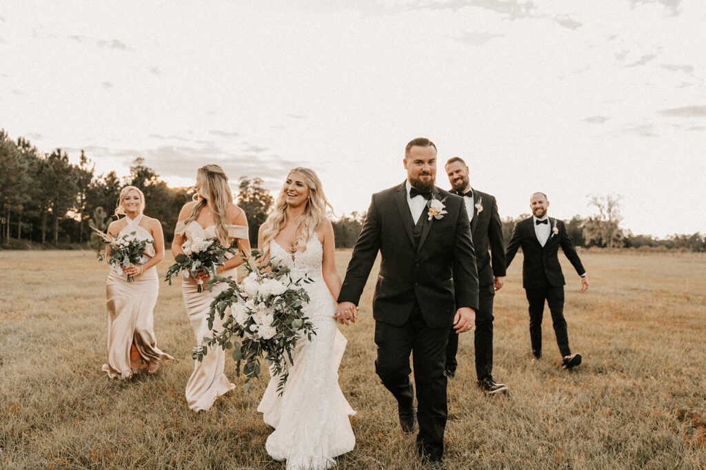 bride and groom walking to their boho themed reception with their bridesmaids and groomsmen