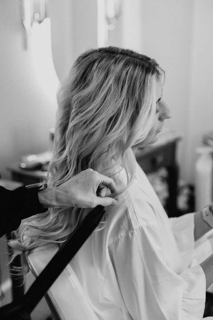 b&w photo of the bride getting her hair done before her boho wedding day 