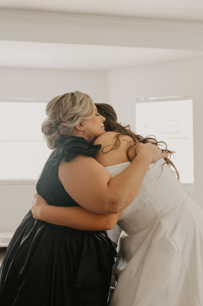 bride and her mom hugging before the elegant wedding day ceremony