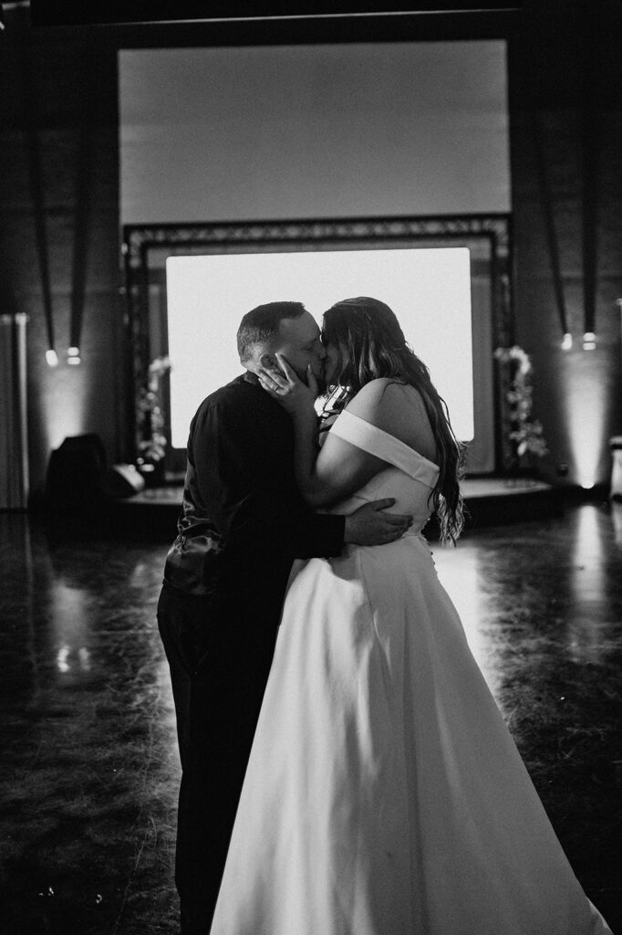 couple kissing at the end of their reception party 