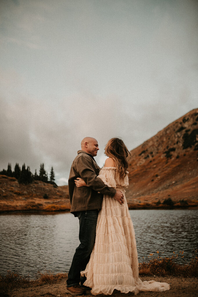 couple smiling at each other during their adventurous couple session 