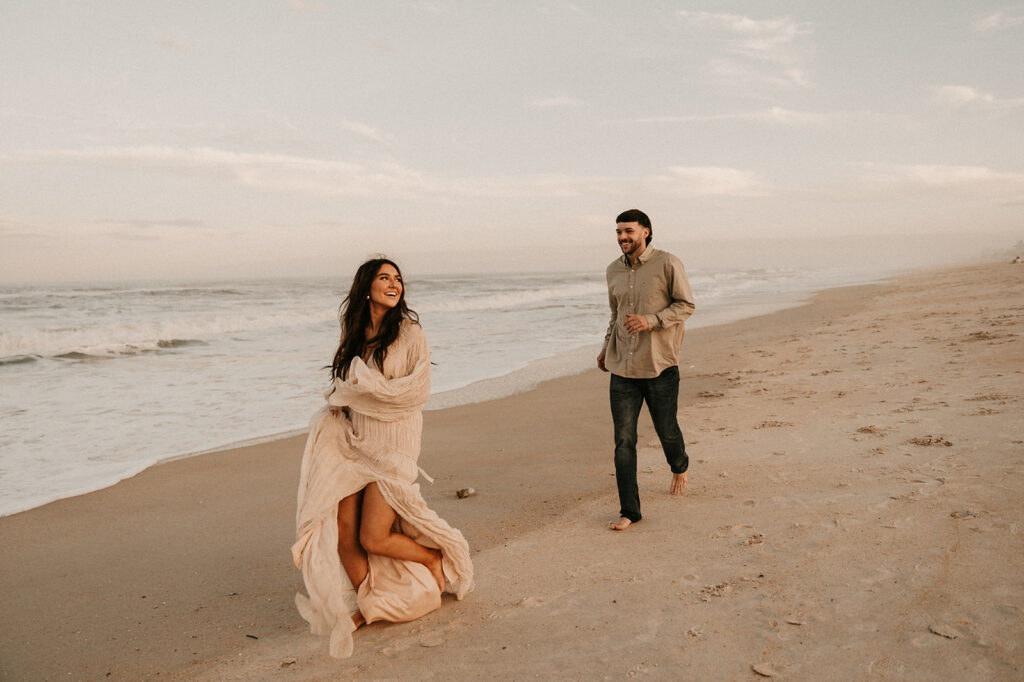 newly engaged couple running at the beach - intimate proposal 
