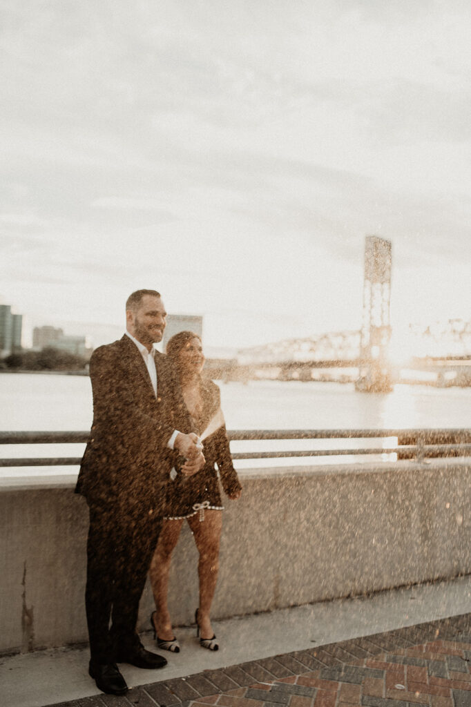 couple celebrating their engagement session with champagne 