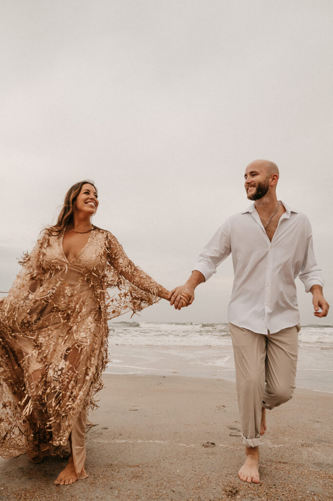 couple walking around the beach during their romantic beach proposal 