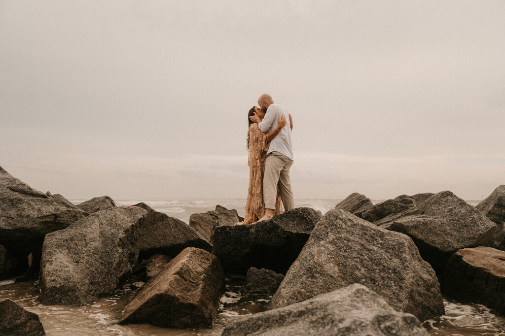 couple hugging during their romantic beach proposal photoshoot