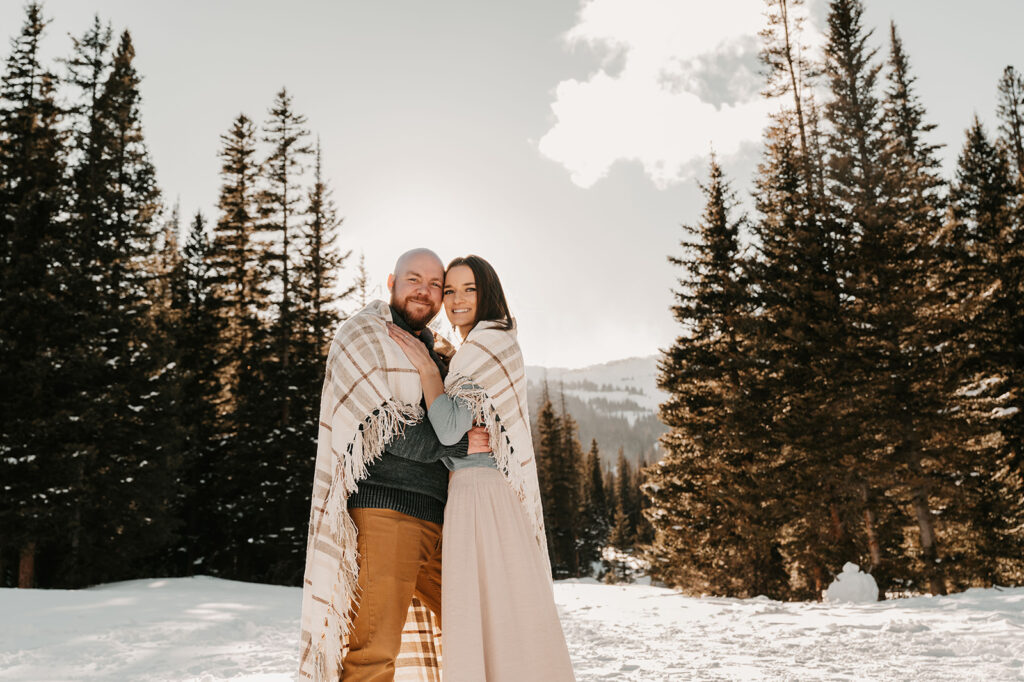 beautiful couple smiling during their snowy & adventurous engagement session 