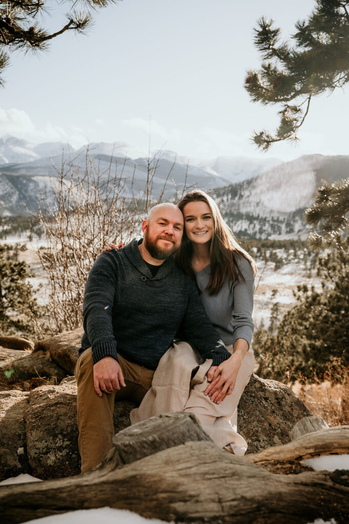 cute couple looking at the camera during their snowy & adventurous engagement session 