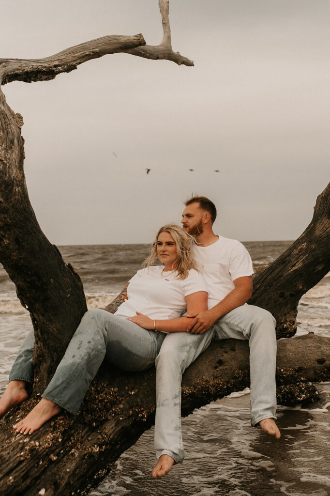 couple sitting at the beach during their photoshoot 