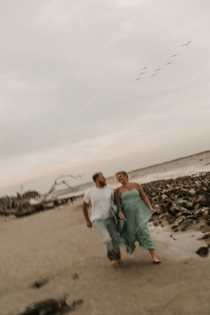 couple running around the beach 