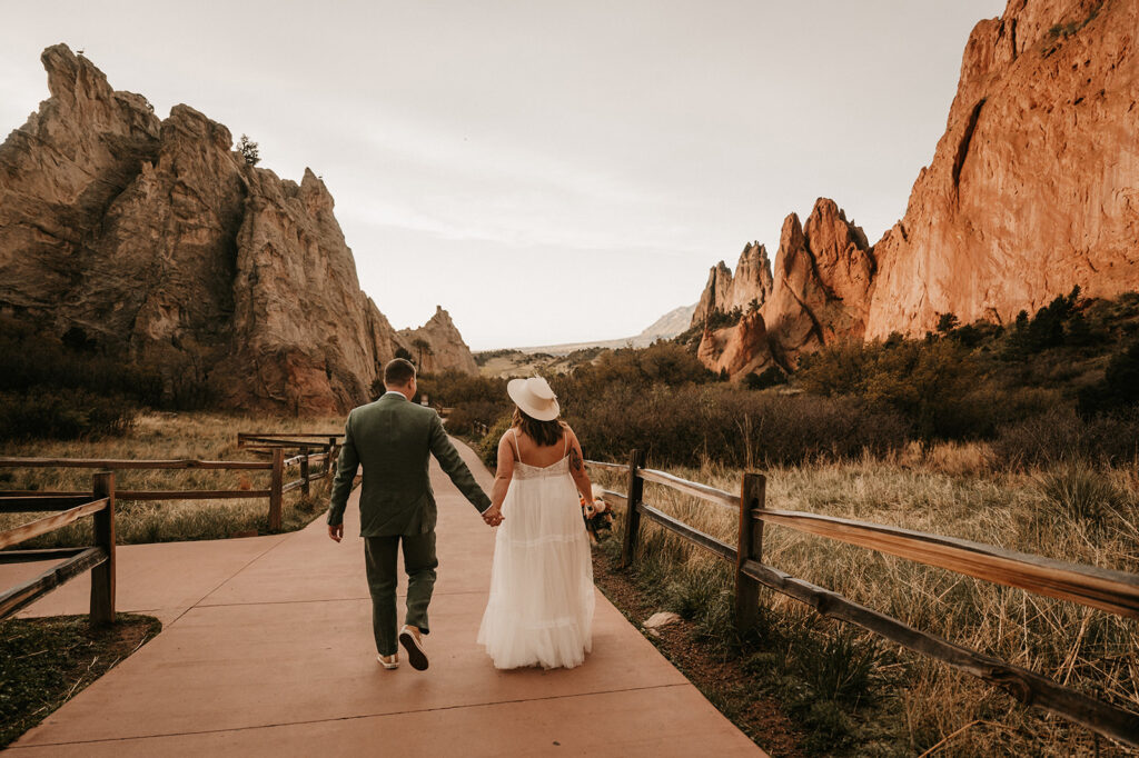 couple holding hands walking around their elopement location