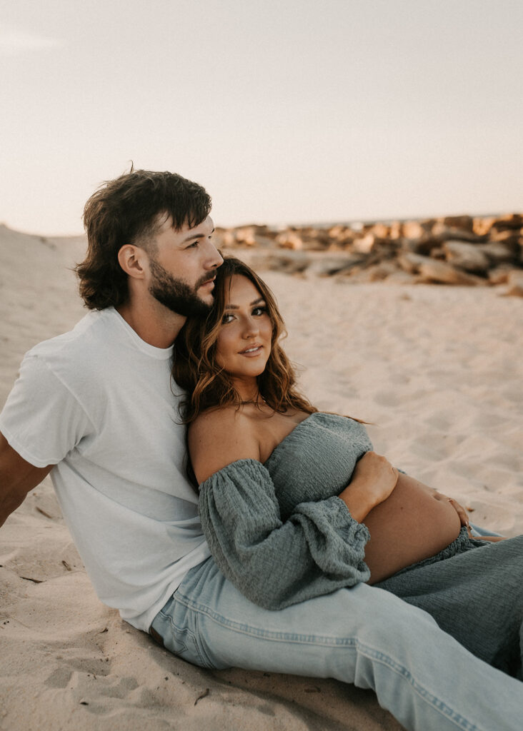 couple looking at the camera during their maternity photoshoot