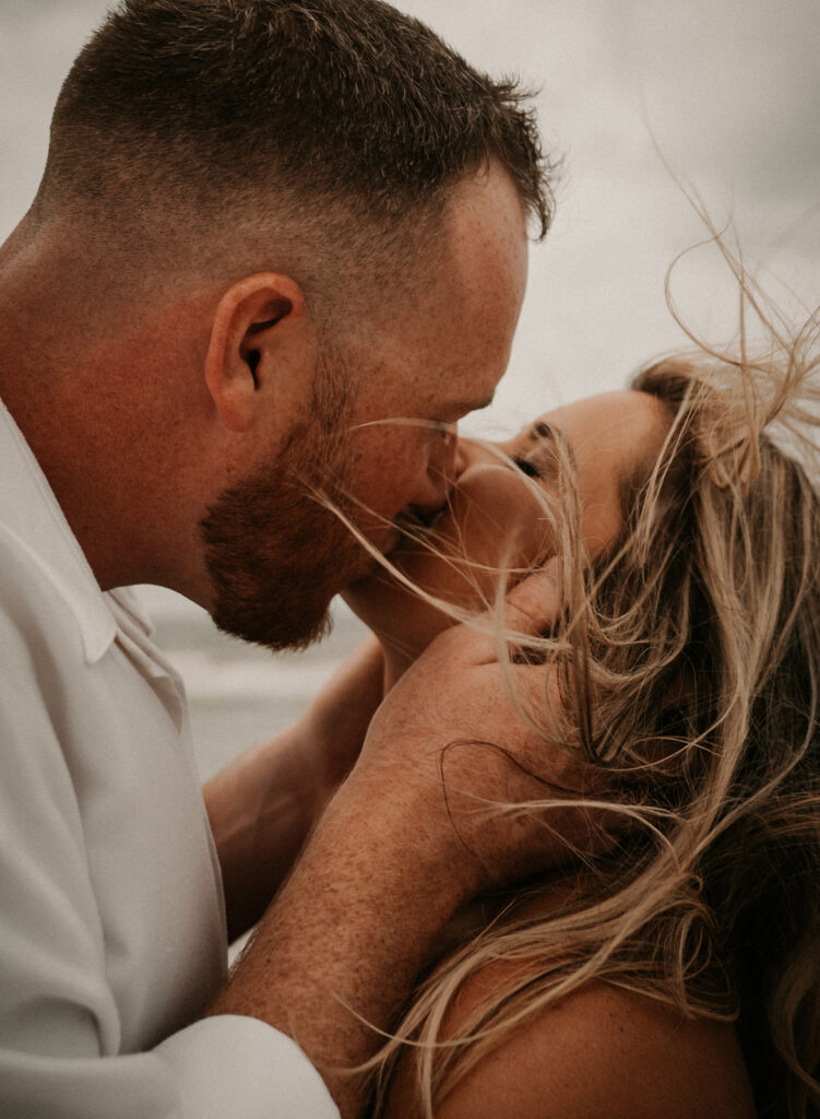 happy couple kissing during their Romantic Beach Engagement Session in St. Augustine, FL