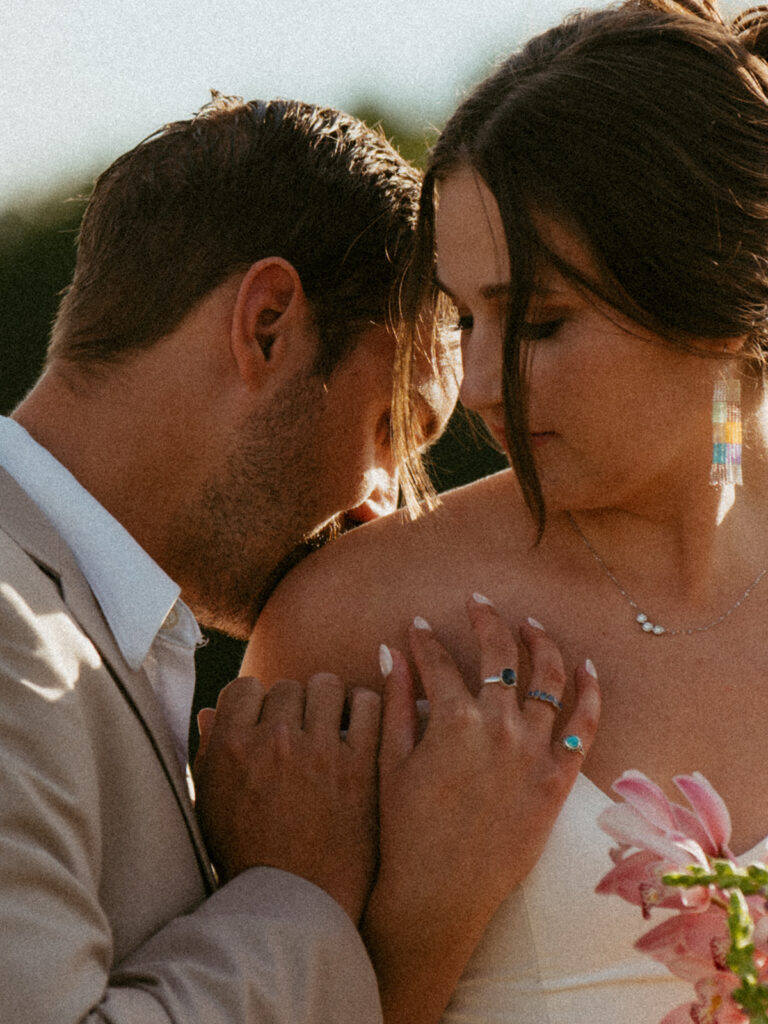 groom kissing the bride on the shoulder 