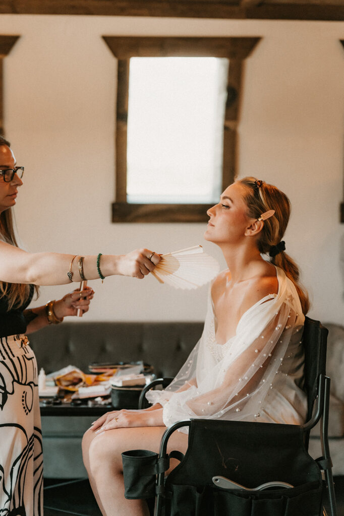 bride getting her makeup done for her ceremony