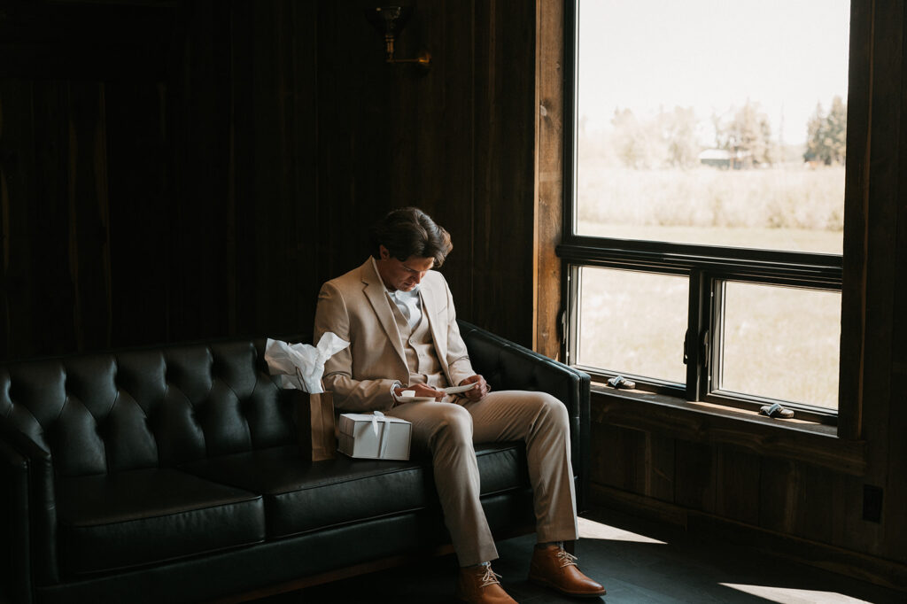 groom opening a gift the bride gave him