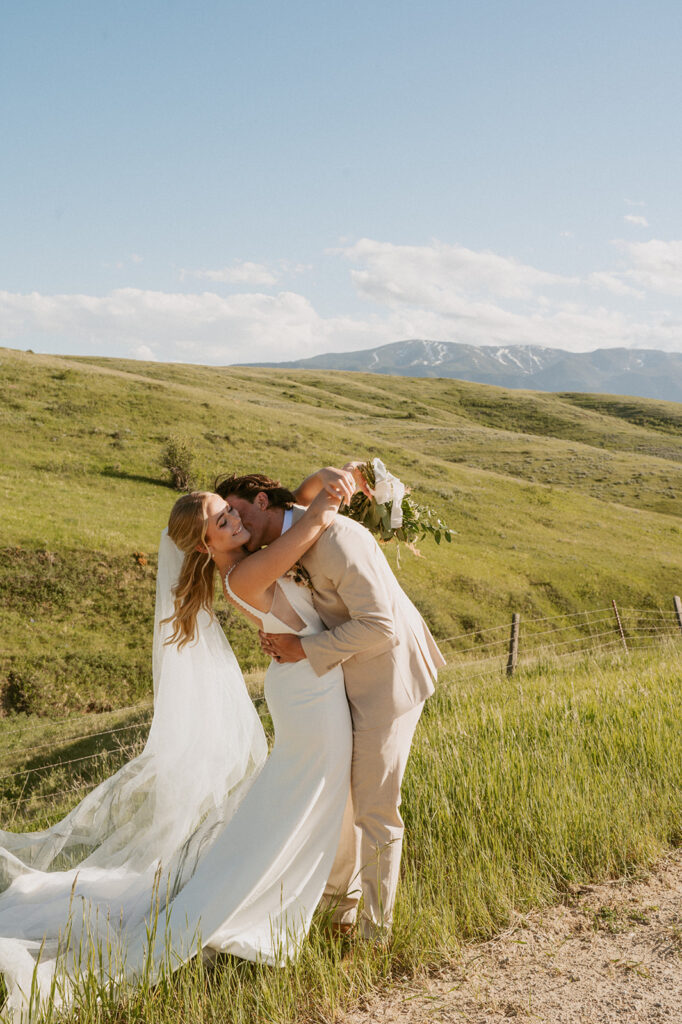 groom kissing the bride on the cheek at their classy western wedding