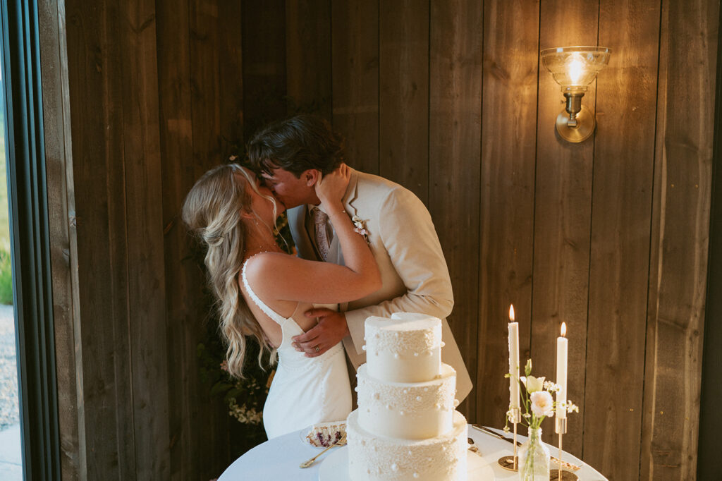 newlyweds kissing after their wedding cake 