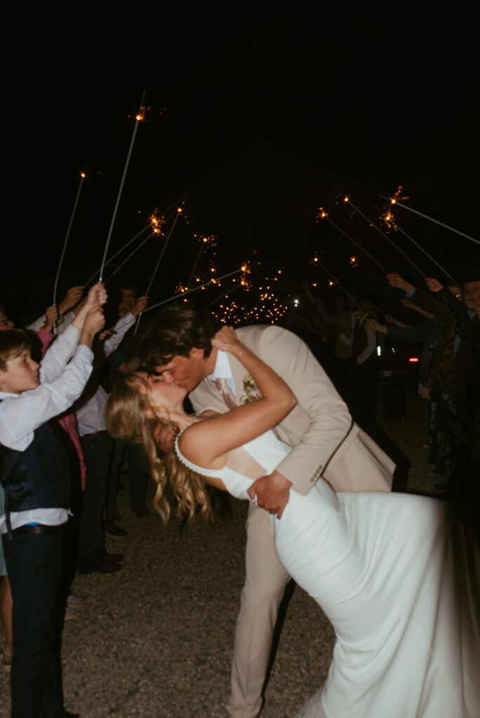 bride and groom kissing after their wedding reception