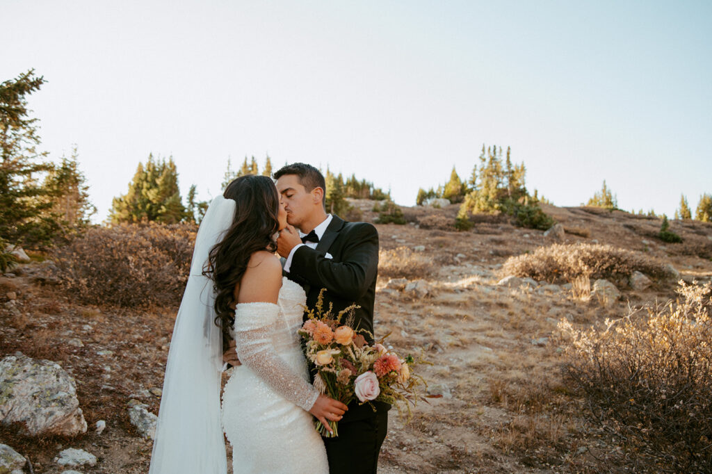 stunning portrait of the bride and groom kissing after their ceremony