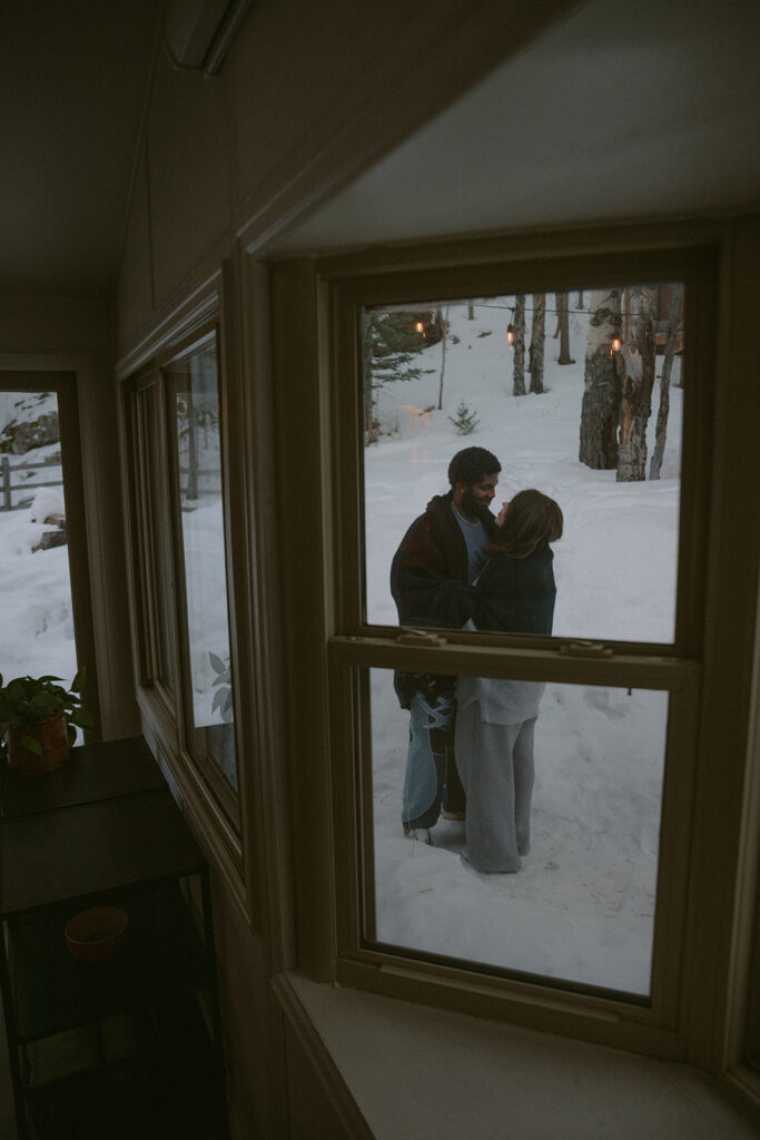 couple playing in the snow during their cozy couple session