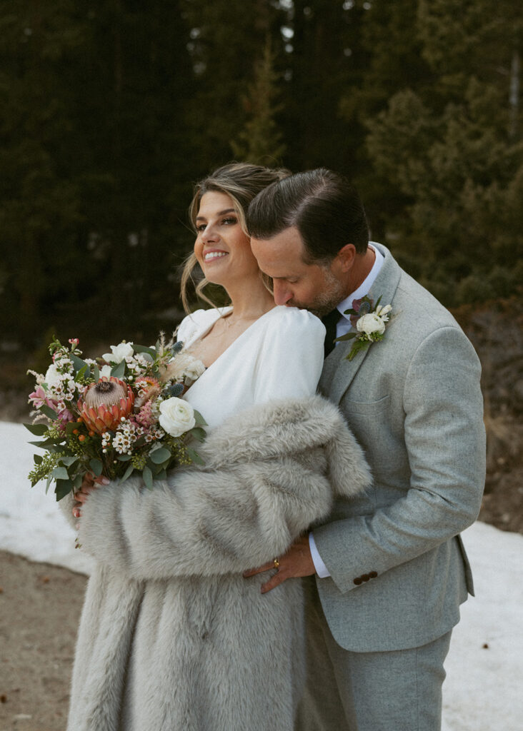 groom kissing the bride on the shoulder 