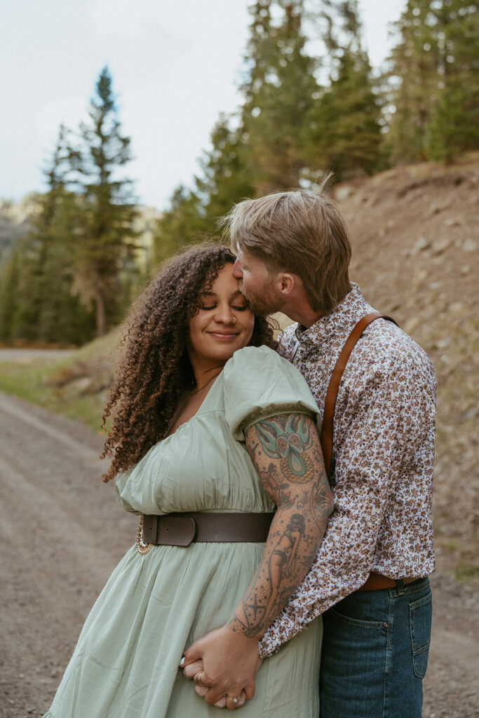 husband kissing his wife on the forehead 