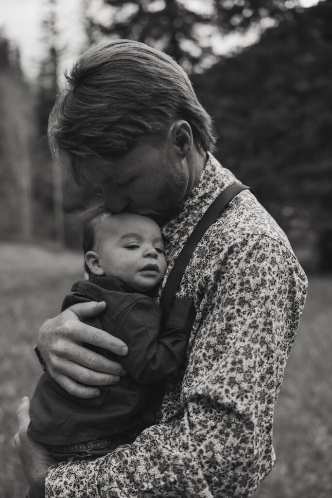 dad kissing his son on the forehead