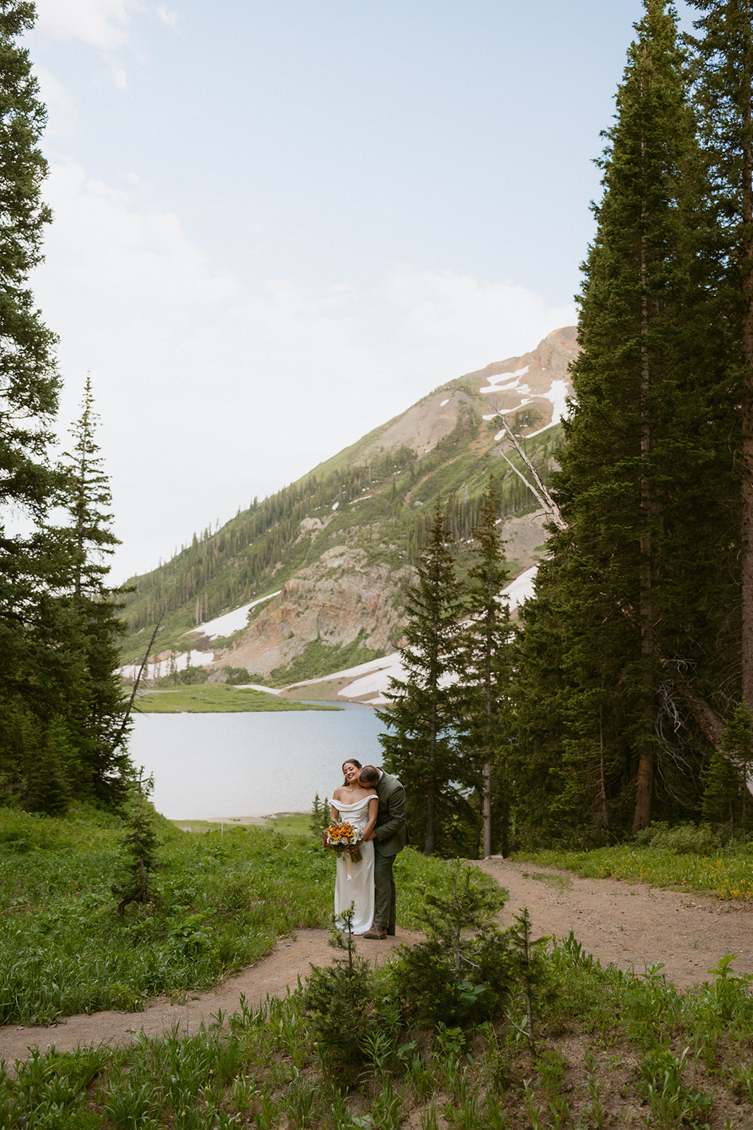 groom kissing the bride on the neck