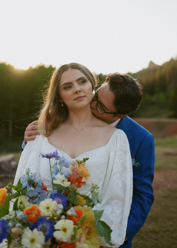 groom kissing the bride on the neck