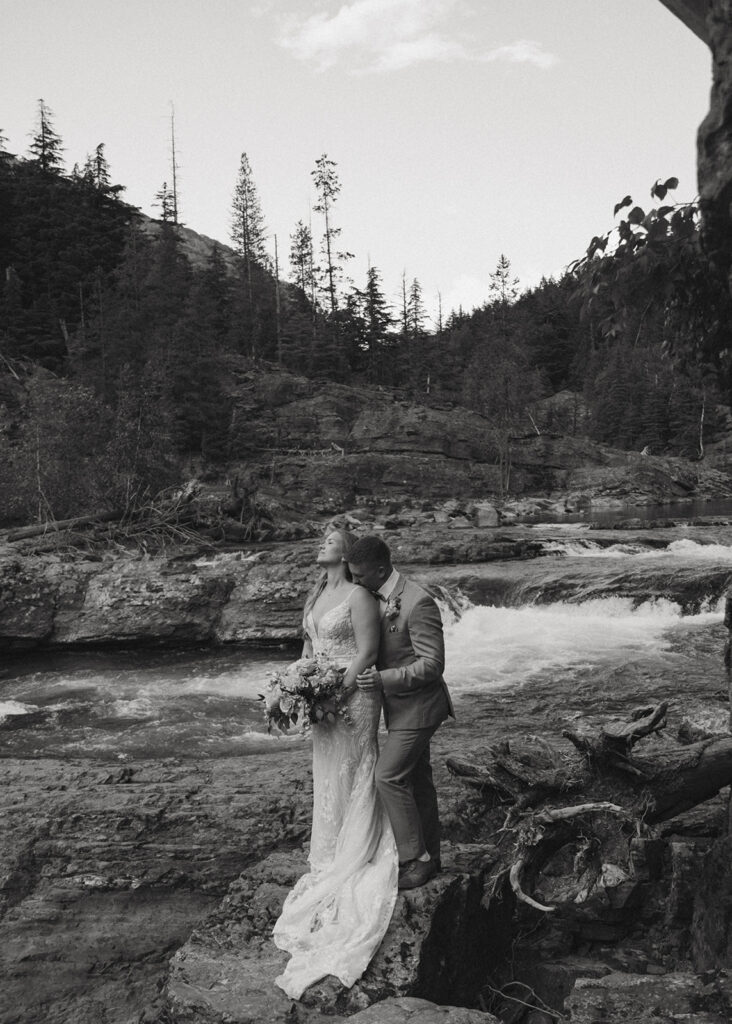 Picture of the groom, kissing the bride on the shoulder