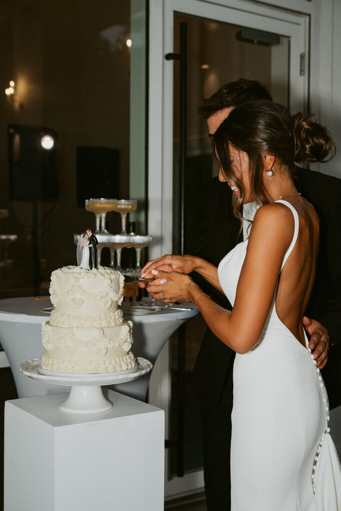 Newly married couple cutting their wedding cake