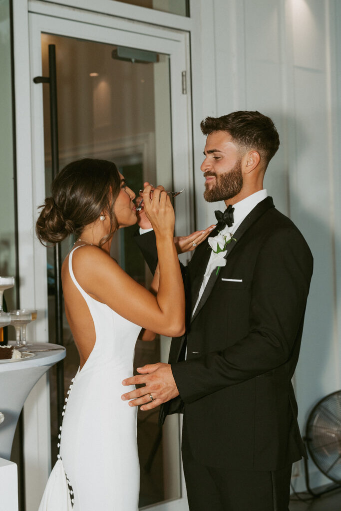 newlyweds trying their wedding cake