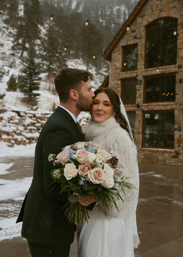 groom, kissing the bride on the forehead