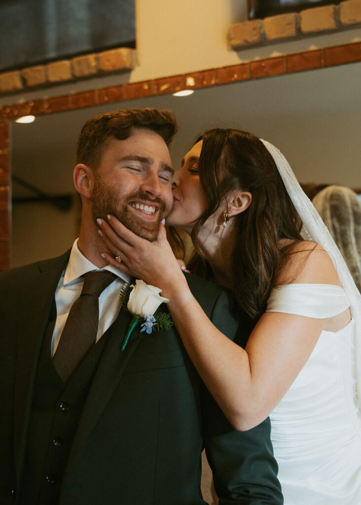 bride kissing the groom on the cheek
