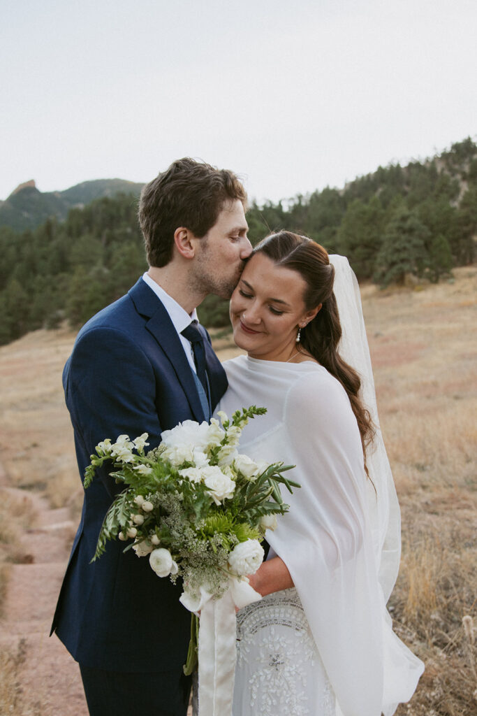 groom kissing the bride on the forehead