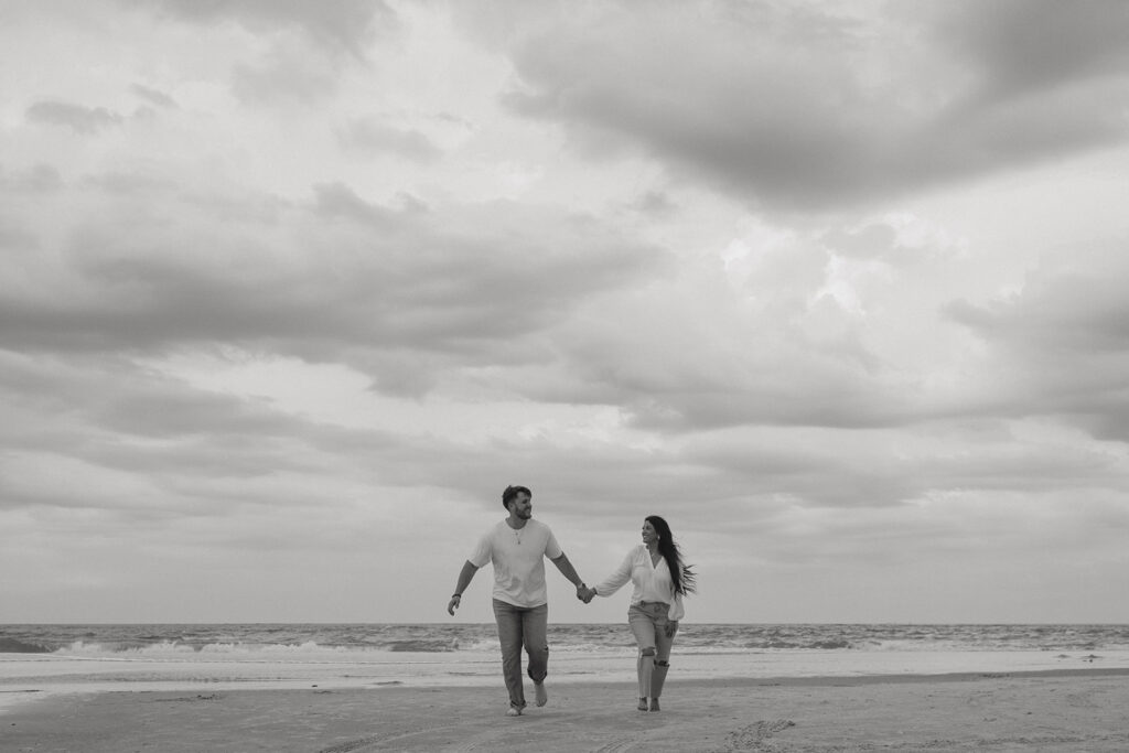 couple running around the beach during their photoshoot