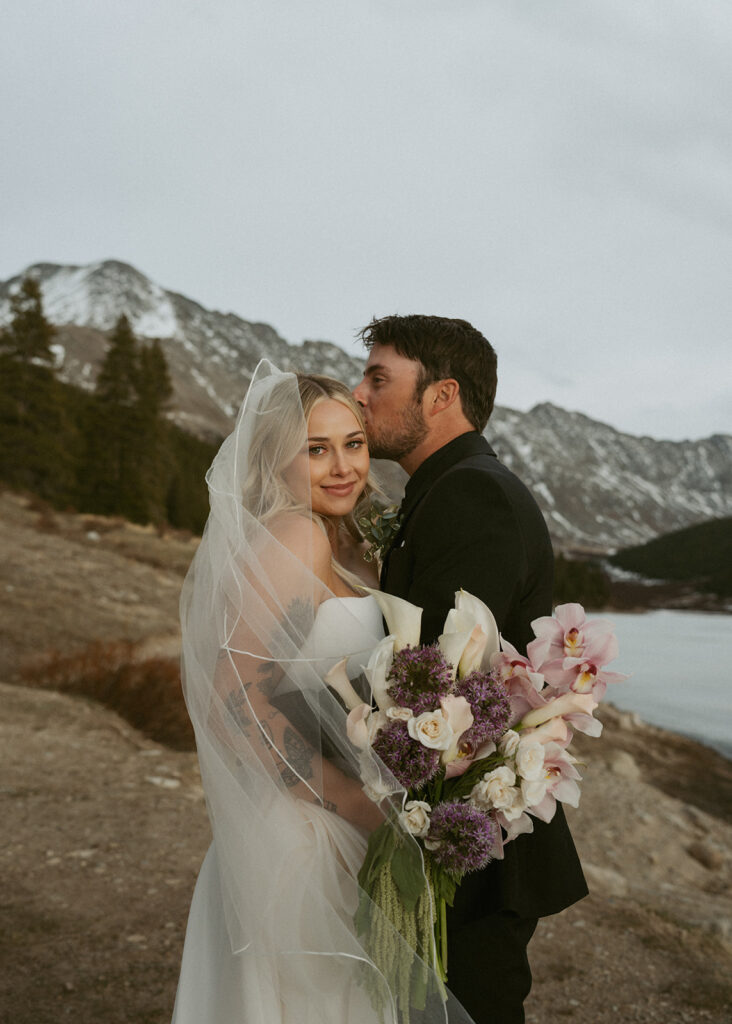 groom kissing the bride on the forehead