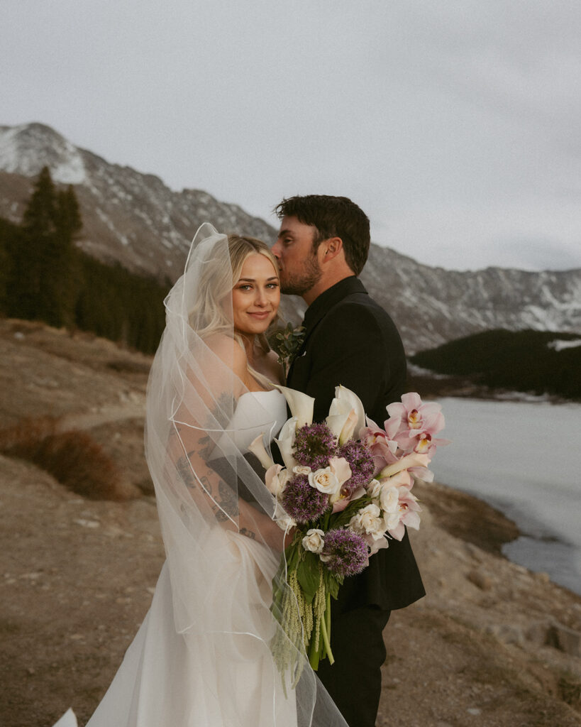 groom kissing the bride on the forehead