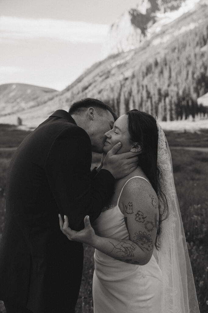 groom kissing the bride on the cheek
